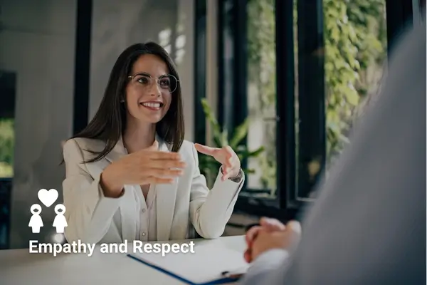 Business meeting with a smiling woman in conversation, emphasizing empathy and respect.